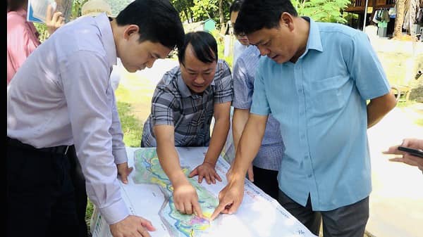 A group of men looking at a map

Description automatically generated